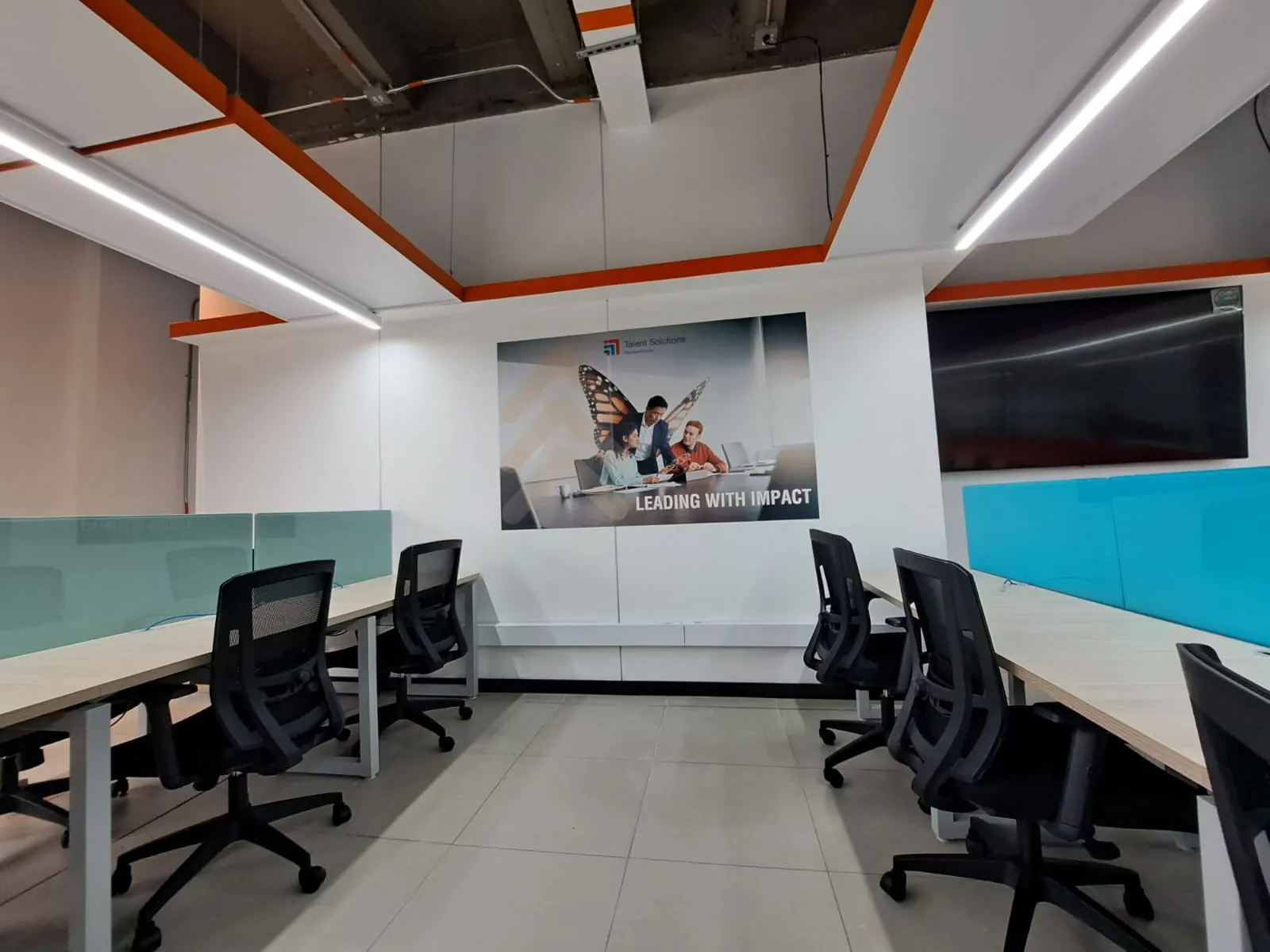 Oficina adecuada con gráfica de pared y franja naranja en el techo