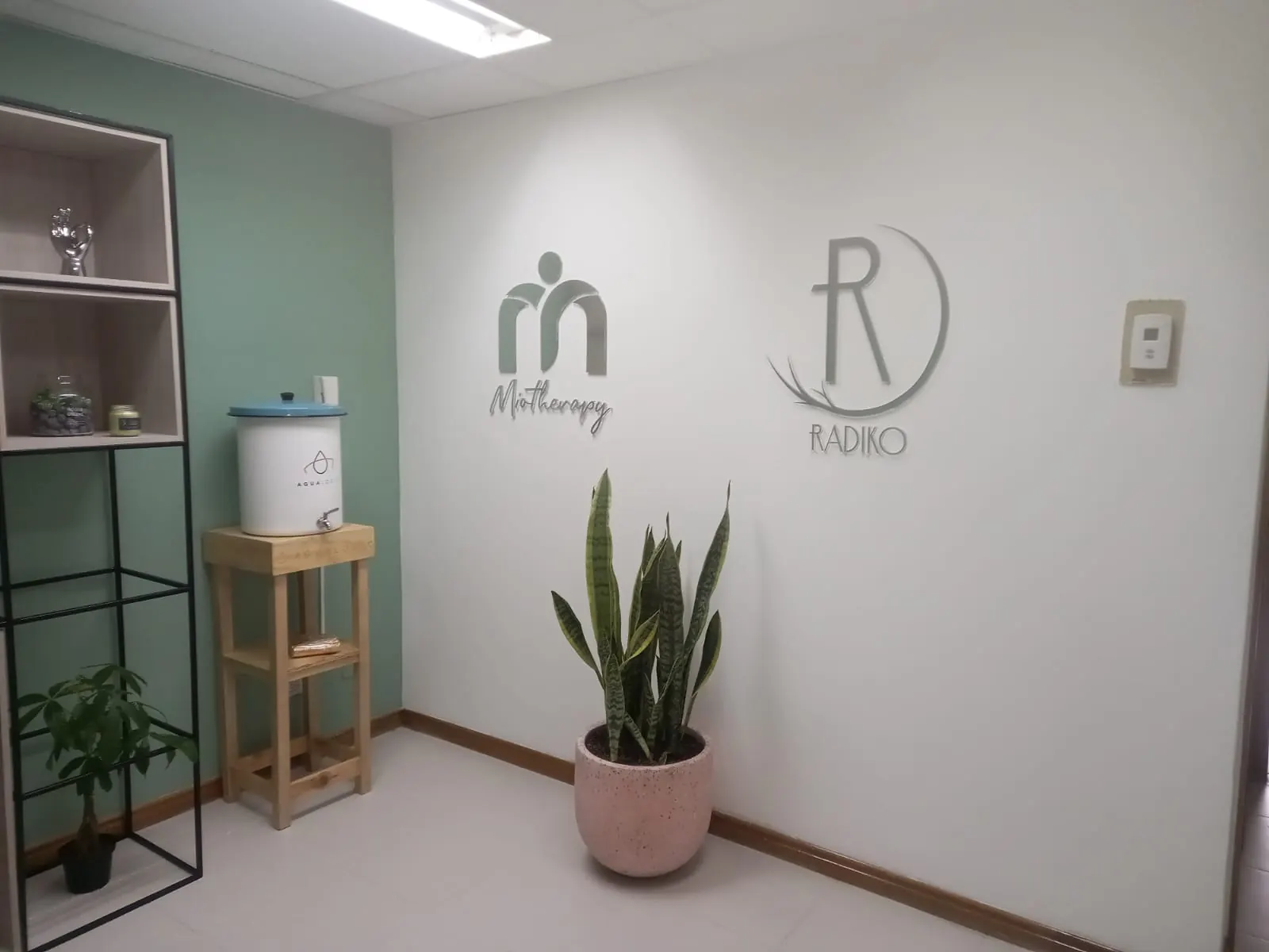 Logos en relieve sobre pared de una oficina con detalles en madera