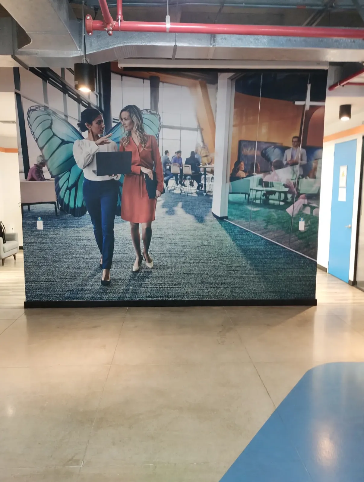 Mural en gran formato con fotografía de personas en una oficina