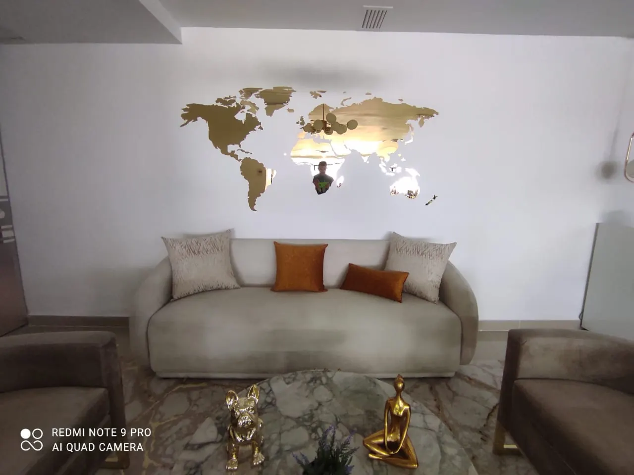 Mapa mundi en acrílico dorado sobre la pared de una sala