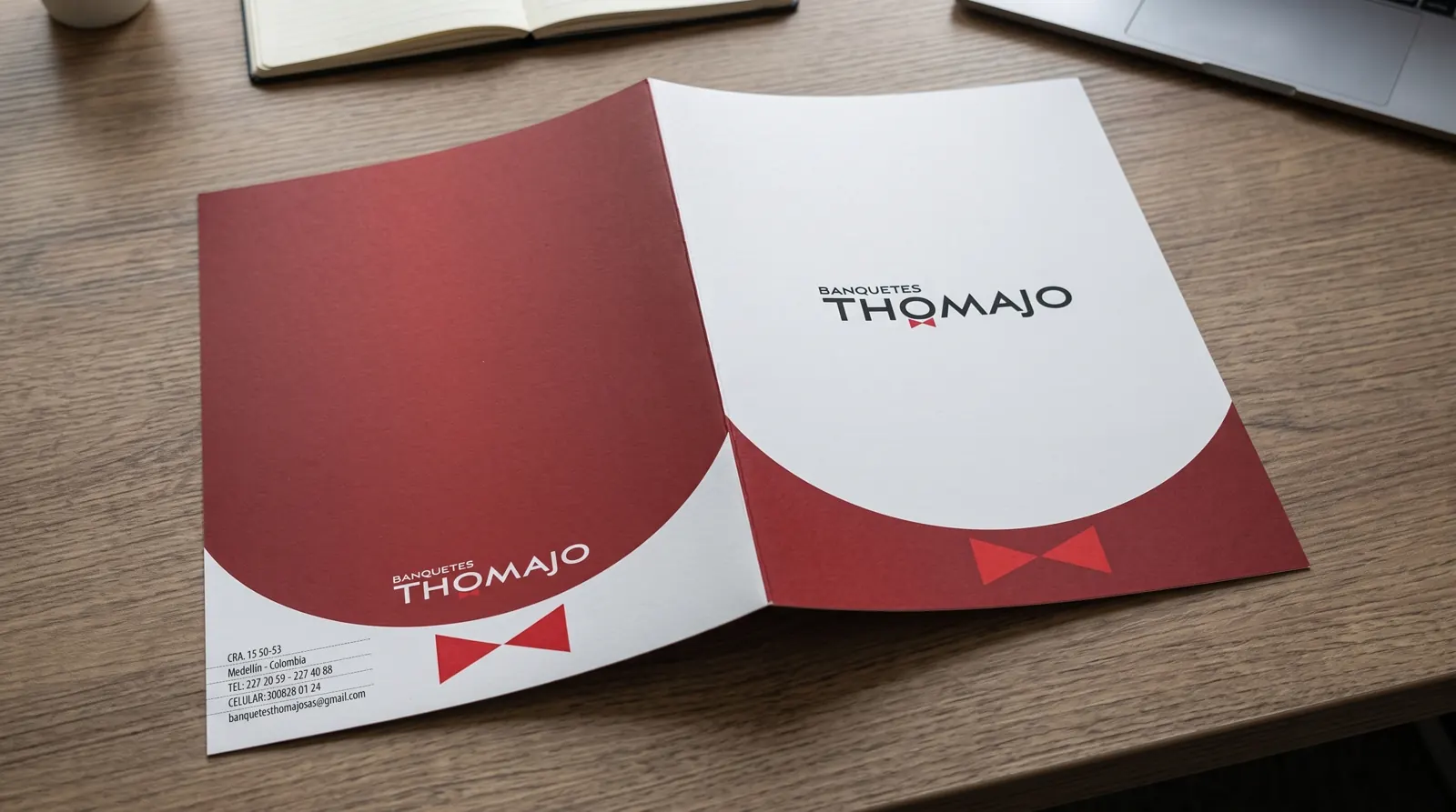 Carpeta corporativa con diseño en rojo y blanco sobre mesa de madera