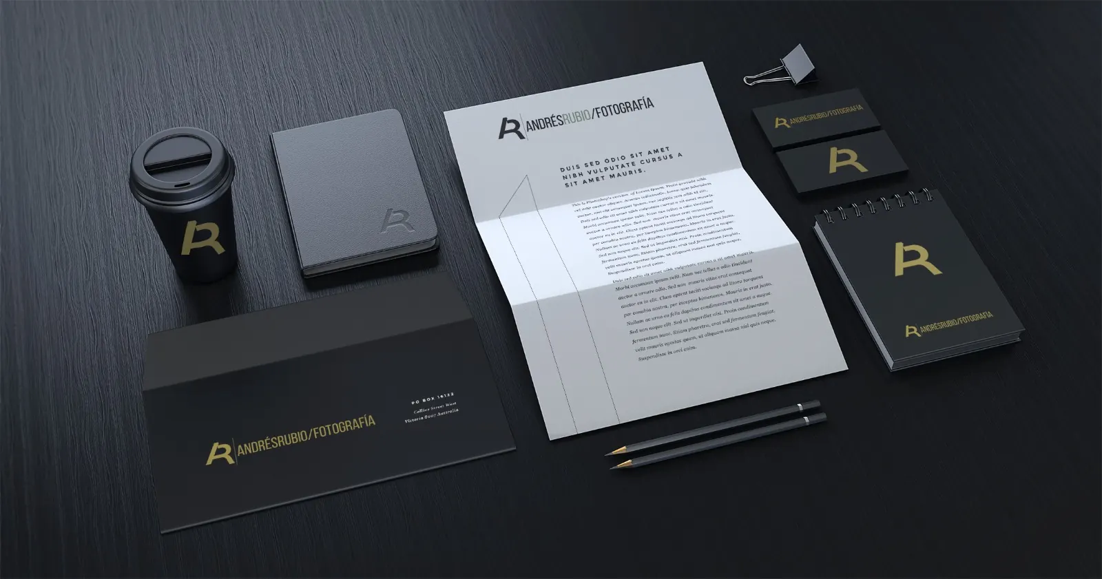 Papelería ejecutiva en negro con logo dorado: sobre, hoja carta y tarjetas