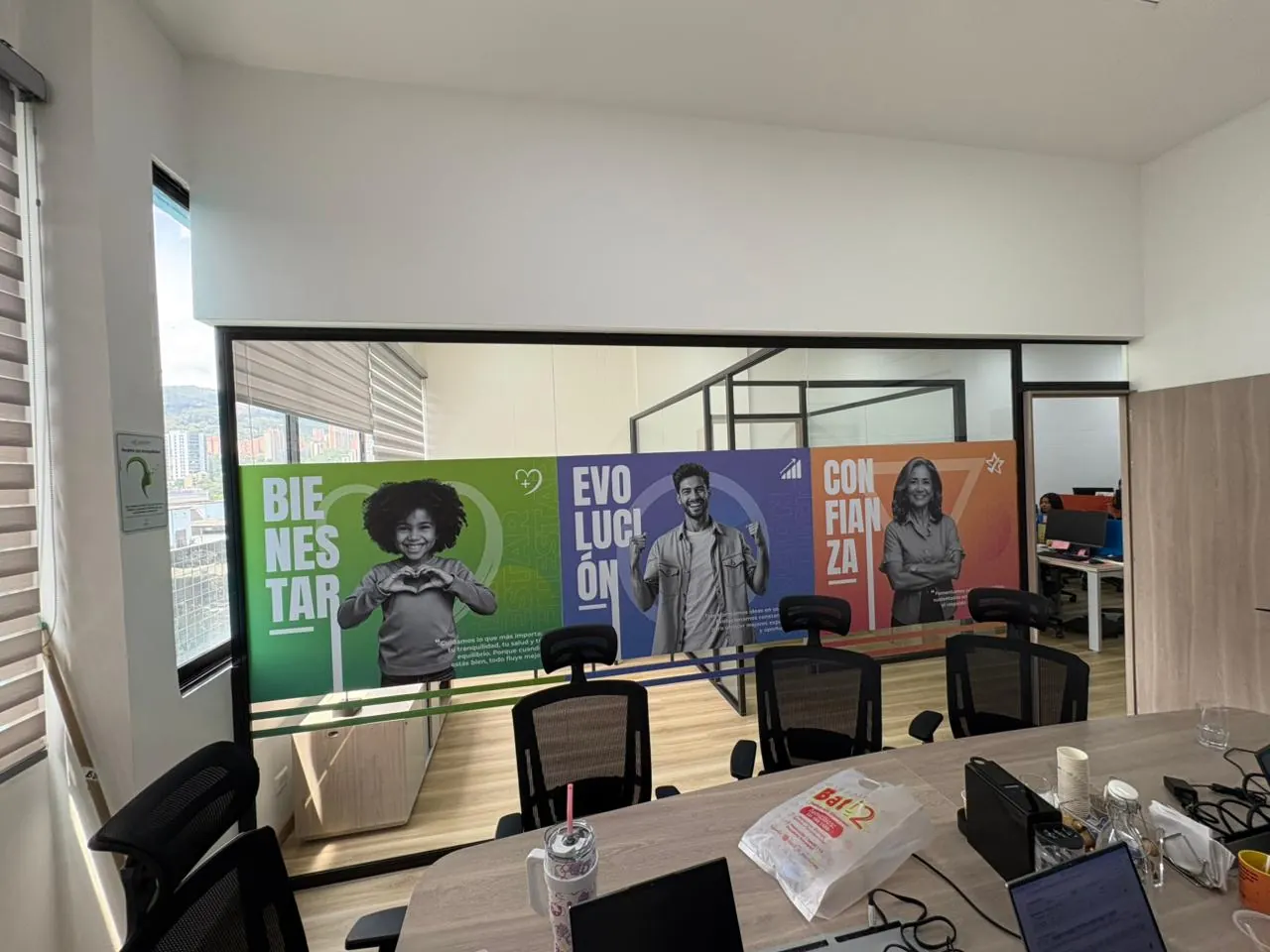 Divisiones de vidrio de una sala de reuniones con vinilo de colores y mensajes de marca