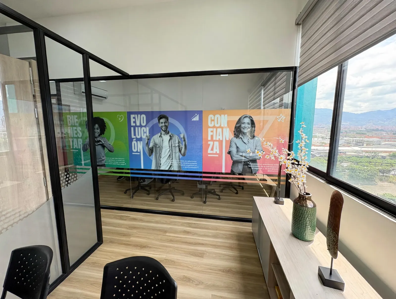 Divisiones de vidrio con vinilo de colores en una sala de reuniones con vista